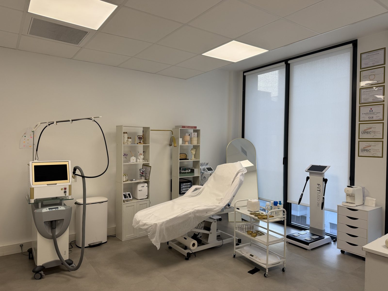 La salle de soins : table de soin, laser et grandes fenêtres